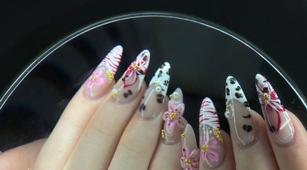 Intricate floral nail art at Nailsbyaimz, Kempston, England, GB, showcasing delicate pink and gold designs.