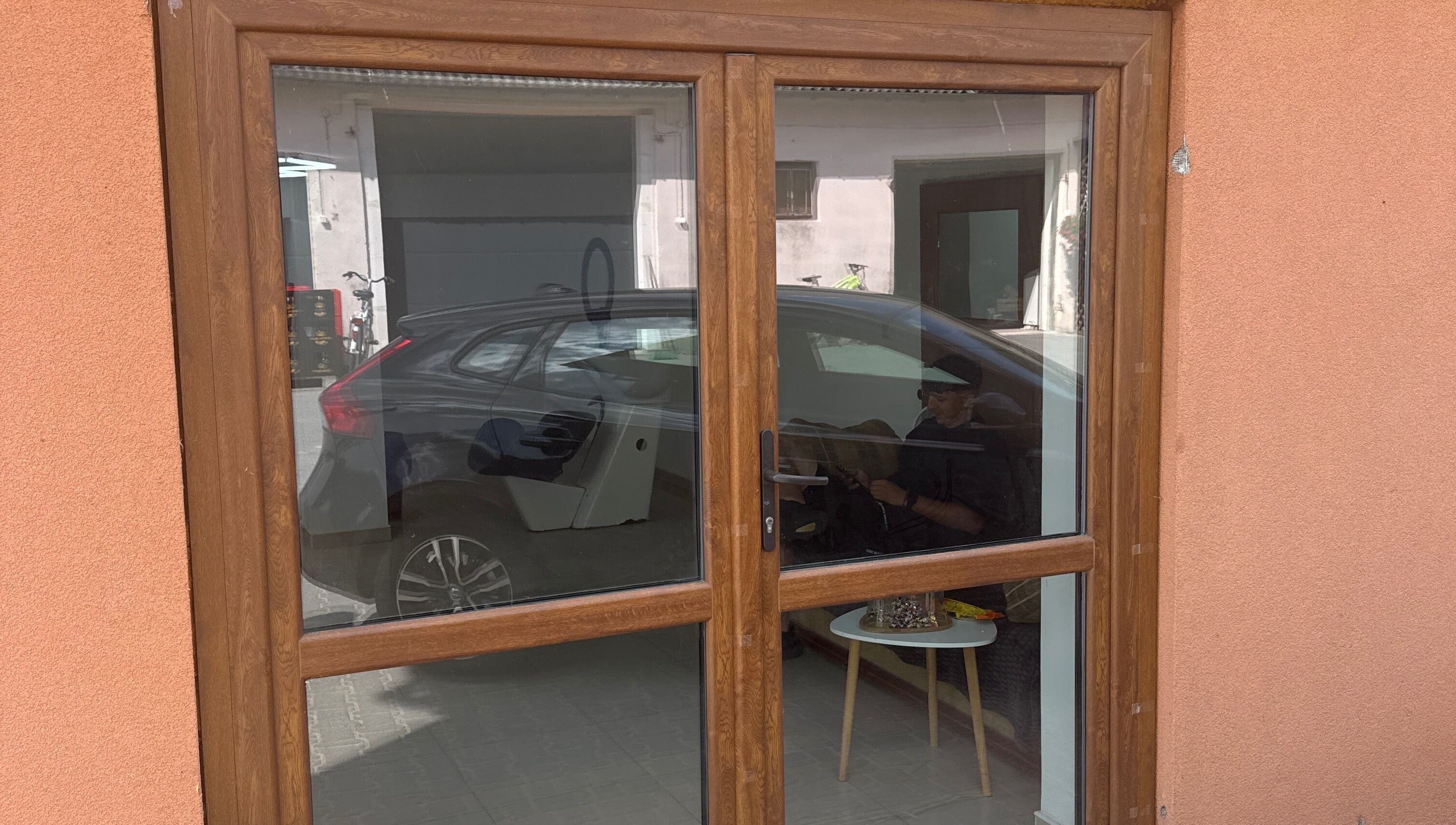 Wejście do Barberek w Wizna, Województwo Podlaskie z odbijającym się wnętrzem w szybie okna.