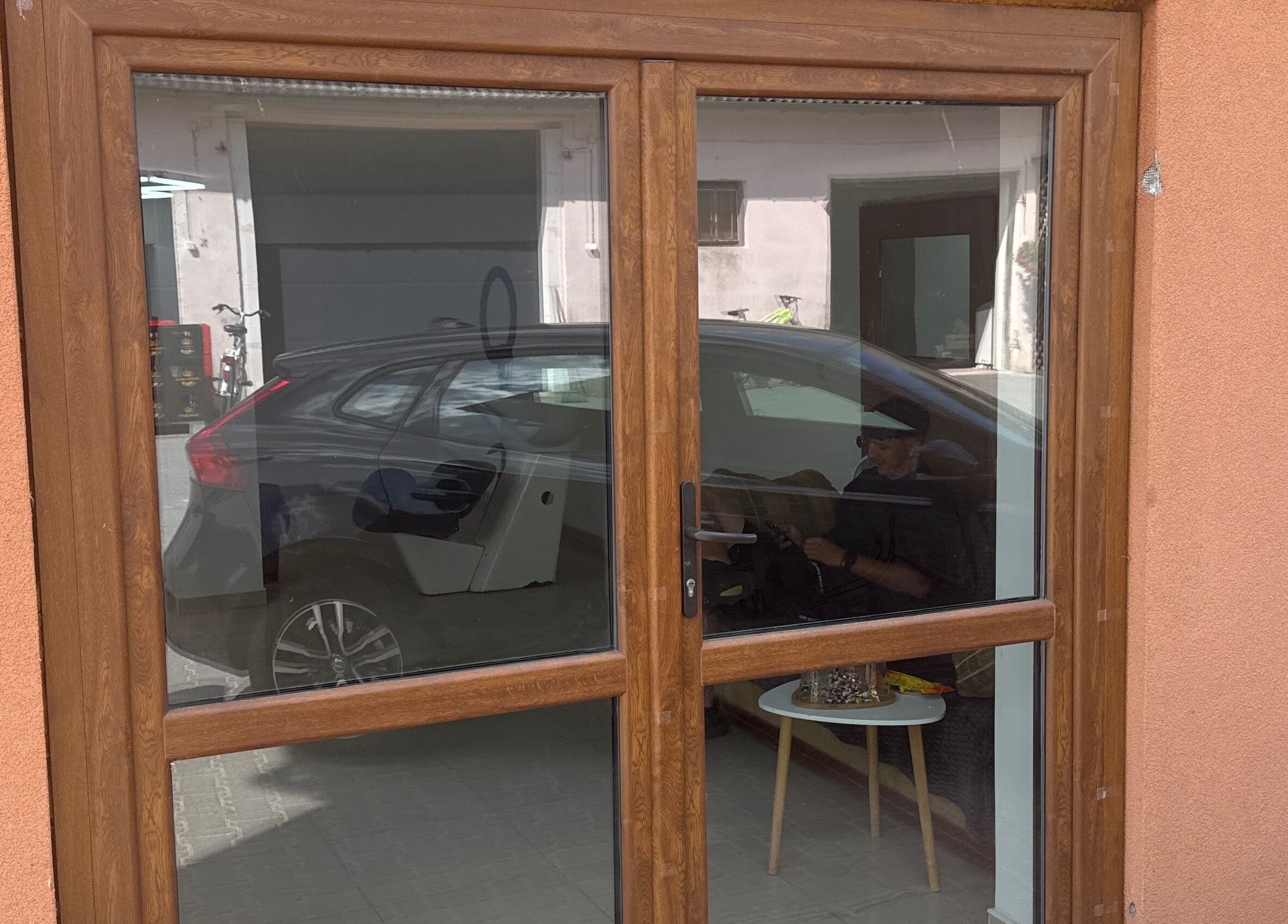 Wejście do Barberek w Wizna, Województwo Podlaskie z odbijającym się wnętrzem w szybie okna.