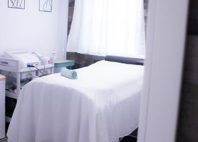 Cozy treatment room at Calm And Cozy Spa, Long Branch, New Jersey, US, with soft lighting and massage table.