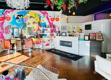 Interior of Jessica Arwand Aesthetics in Cobham, England, GB with colorful wall art and chic salon setup.
