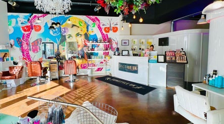 Interior of Jessica Arwand Aesthetics in Cobham, England, GB with colorful wall art and chic salon setup.