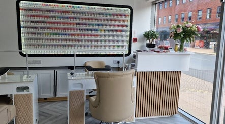 Modern nail bar at Beauty Haus, Wilmslow, England, GB, showcasing a vibrant polish display and chic seating.