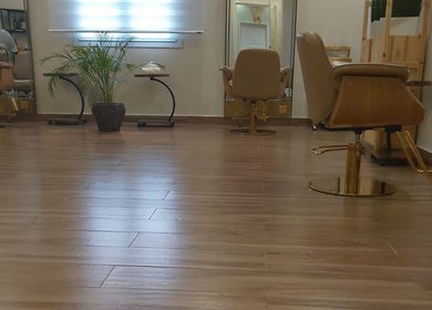 Modern interior of Alzaina salon in Umm Salal Muhammed, featuring sleek chairs and wooden flooring.