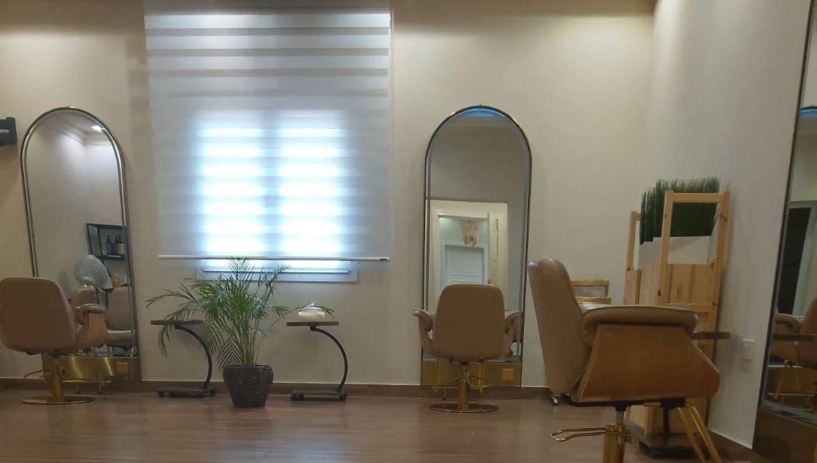 Sophisticated interior of Alzaina Salon in Umm Salal Muhammed, featuring styling chairs and mirrors.