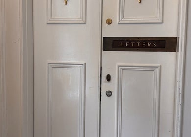 White wooden door with letter slot at La Rosa Blanca | Reiki & Yoga, Glasgow, Scotland, GB.