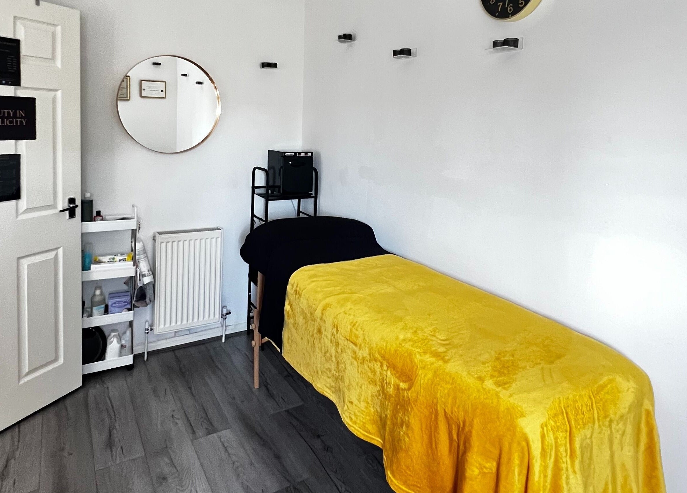 Relaxing treatment room at Beauty In Simplicity, Warrington, England, with a yellow cover on a massage bed.