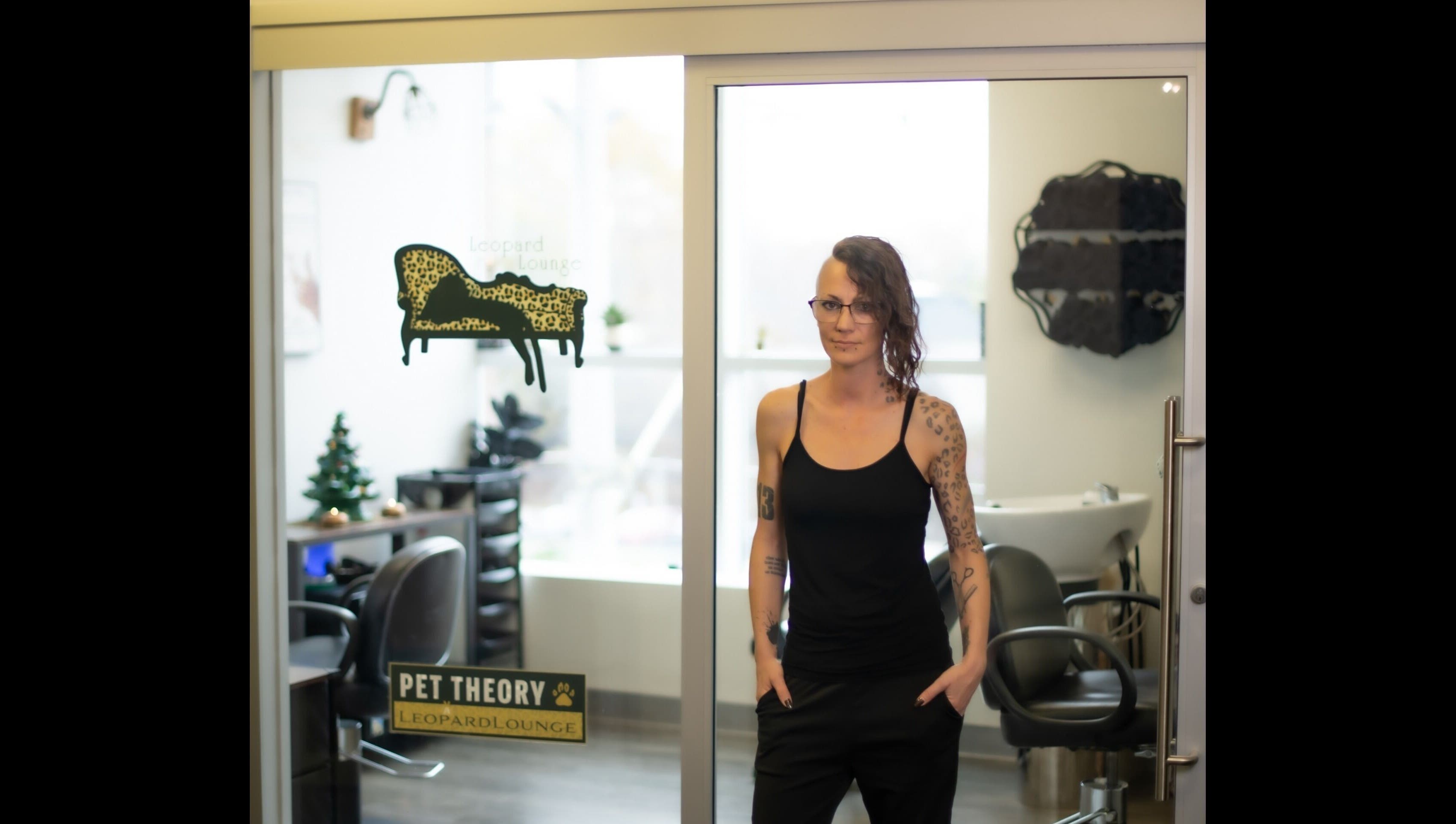 A person stands in front of Leopard Lounge 🐆 ✂️, a chic beauty venue in Mississauga, Ontario, CA with stylish decor.