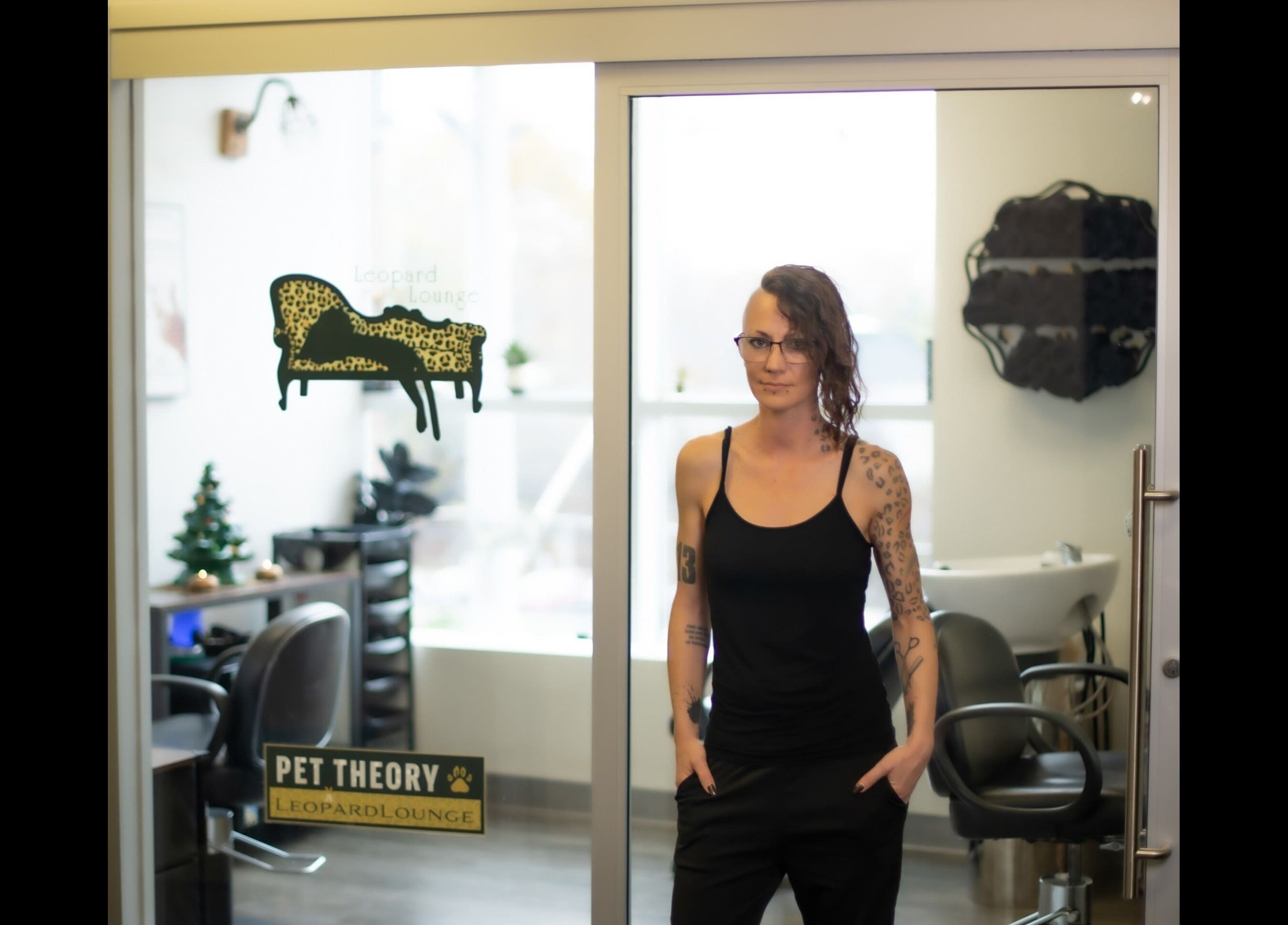 A person stands in front of Leopard Lounge 🐆 ✂️, a chic beauty venue in Mississauga, Ontario, CA with stylish decor.