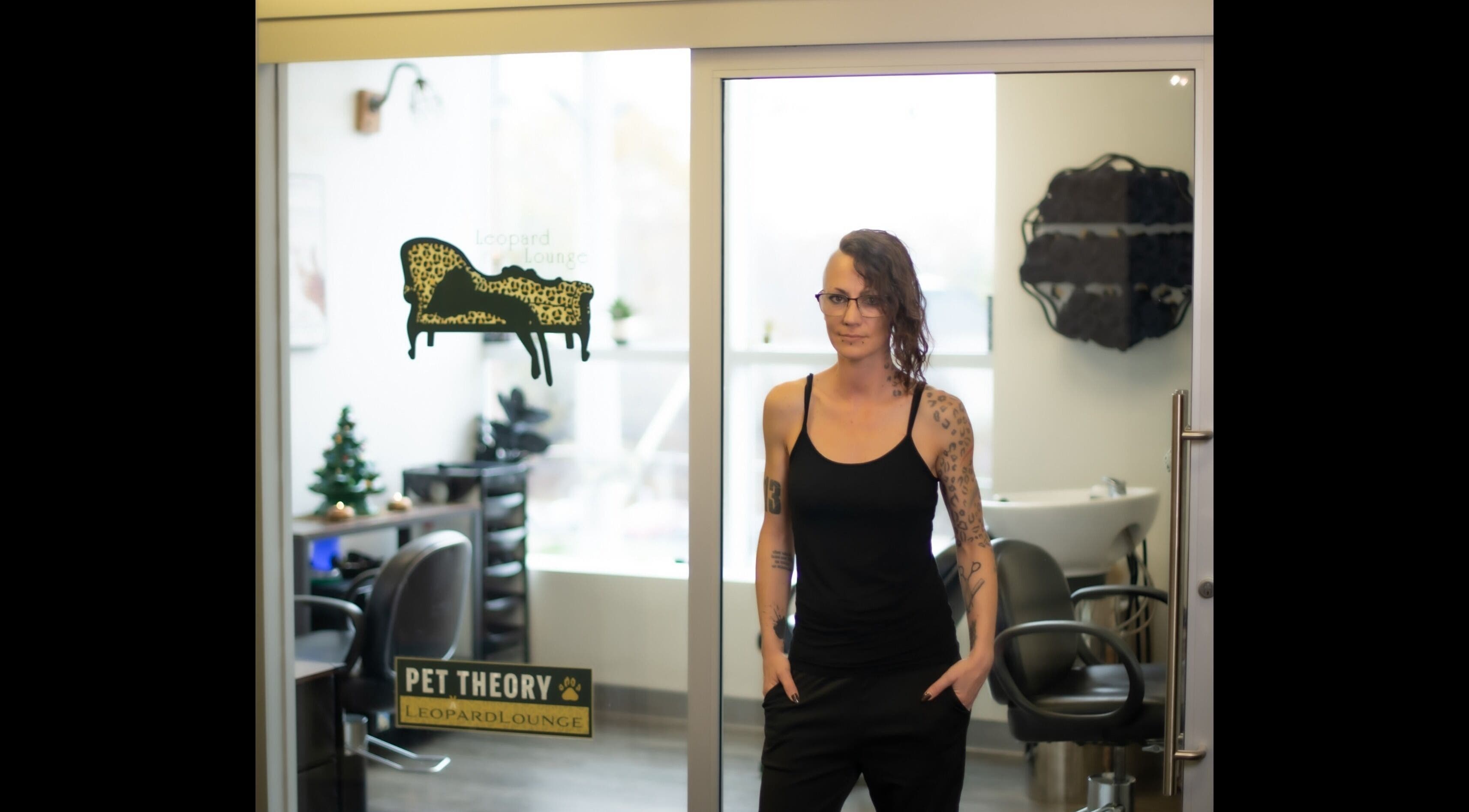 A person stands in front of Leopard Lounge 🐆 ✂️, a chic beauty venue in Mississauga, Ontario, CA with stylish decor.
