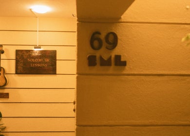 Guitar and sign at Solo Music Lessons, Bengaluru, Karnataka, IN, inviting music enthusiasts.