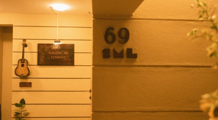 Guitar and sign at Solo Music Lessons, Bengaluru, Karnataka, IN, inviting music enthusiasts.