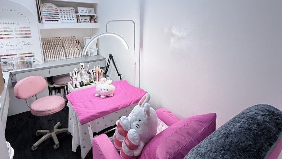 Charming nail salon setup at Nails By Ting, Singapore, SG with pink decor and plush seating.