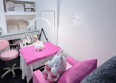 Charming nail salon setup at Nails By Ting, Singapore, SG with pink decor and plush seating.
