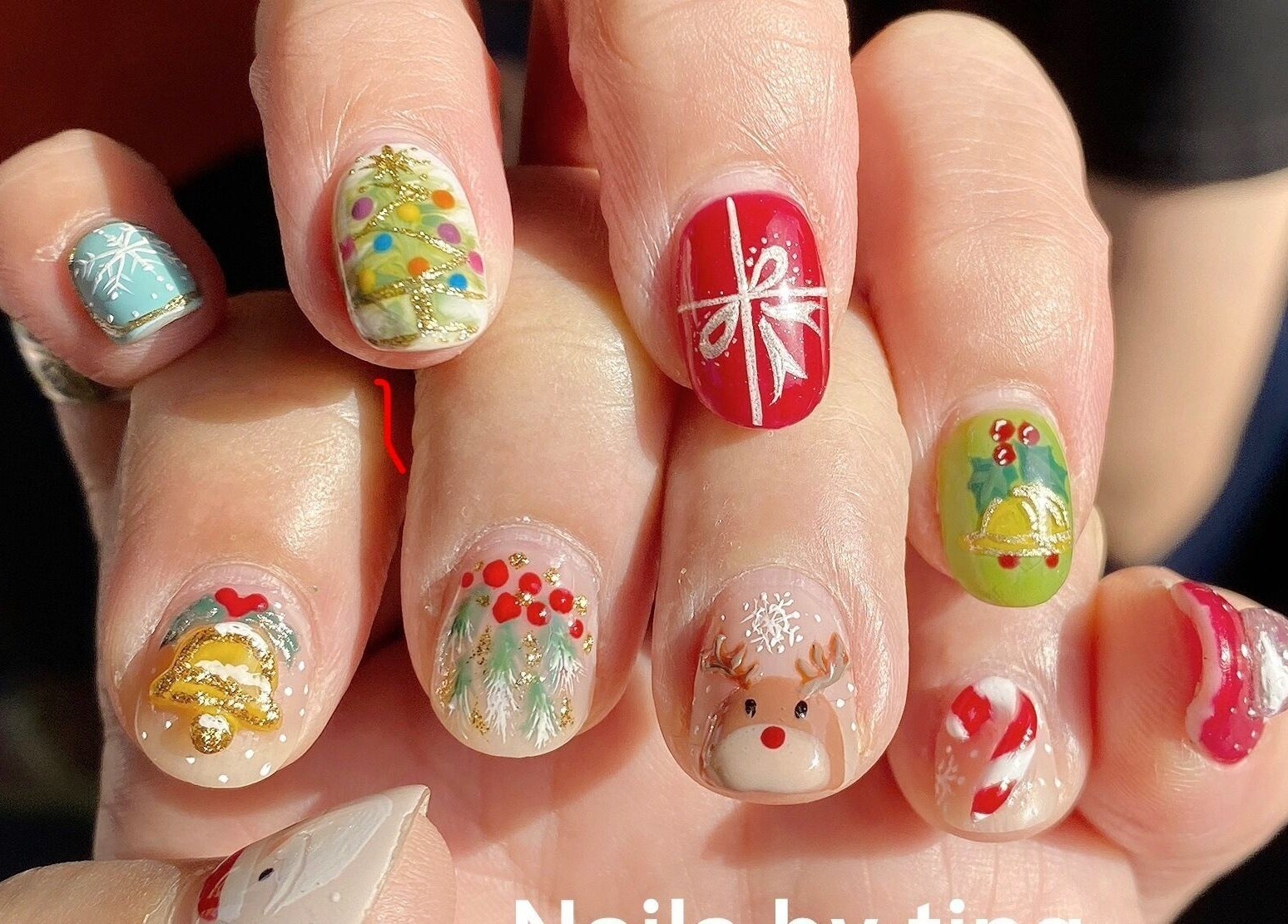 Festive nail art at Nails By Ting, Singapore, SG with holiday designs including reindeer and gifts.