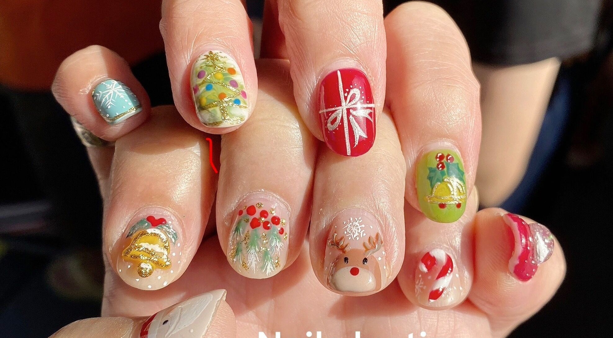 Festive nail art at Nails By Ting, Singapore, SG with holiday designs including reindeer and gifts.