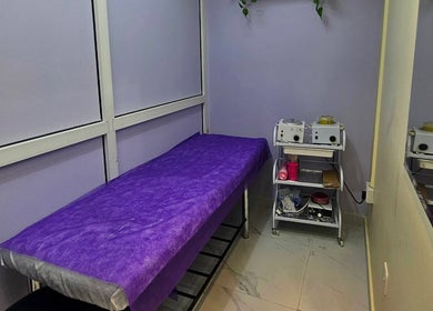Cozy treatment room at Renu Sachdeva Beauty Saloon in Abu Dhabi, Abu Dhabi, AE, featuring a purple-covered bed.