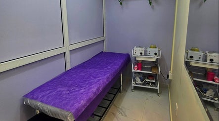 Cozy treatment room at Renu Sachdeva Beauty Saloon in Abu Dhabi, Abu Dhabi, AE, featuring a purple-covered bed.