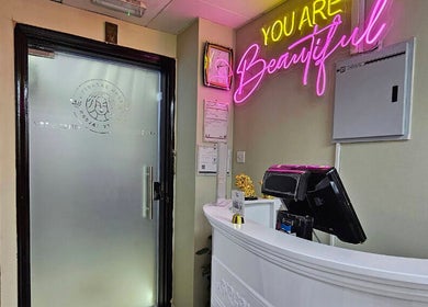 Reception area at Renu Sachdeva Beauty Saloon, Abu Dhabi, AE with a vibrant neon sign.