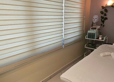 Calm treatment room at Renu Sachdeva Beauty Saloon, Abu Dhabi, AE, featuring a massage bed and spa equipment.