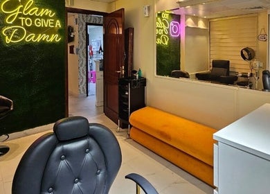Stylish interior of Renu Sachdeva Beauty Saloon, Abu Dhabi, AE with neon sign and modern chairs.