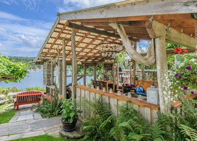 Outdoor rustic patio at Shinrin-Yoku Spa with lush plants, Bamfield, British Columbia, CA.
