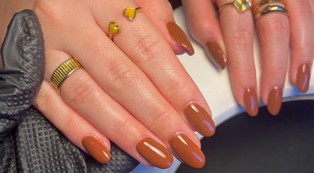 Elegant brown manicure with gold rings at Cured. By Olivia, Cardiff, Wales, GB.