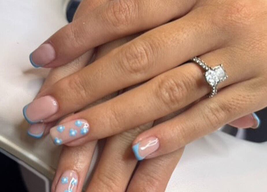 Elegant blue nail art on hands at Just Gel Studio, Kemsing, England, GB. Features intricate gel designs.