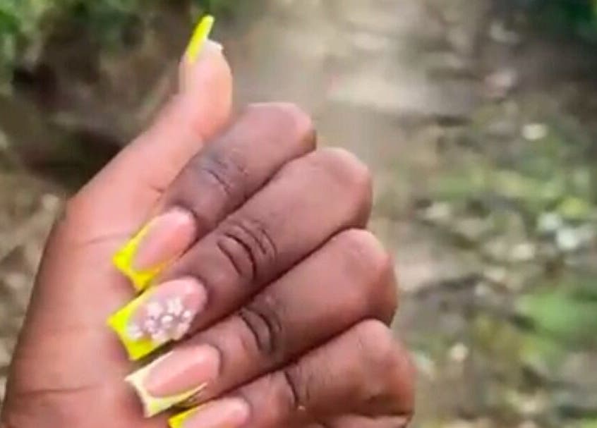 Close-up of floral nail art with yellow accents at Get_nailed784studio, Charlotte, Charlotte, VC.