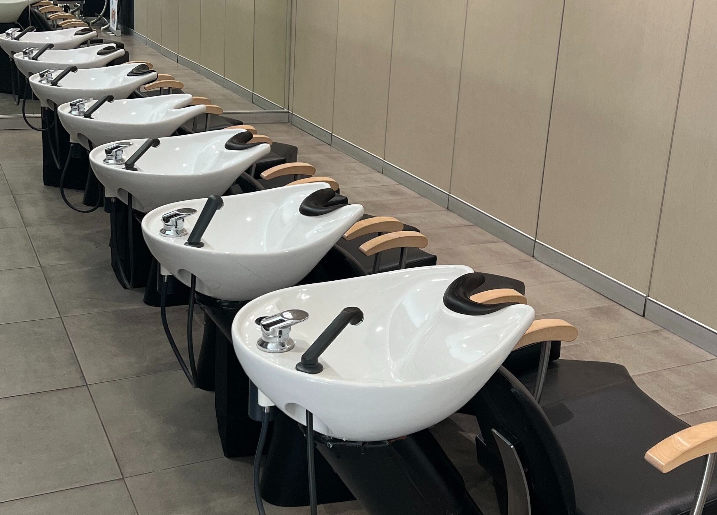 Modern washstations at John Azzi Hairdressers, Sydney, New South Wales, AU, showcasing sleek salon interior.