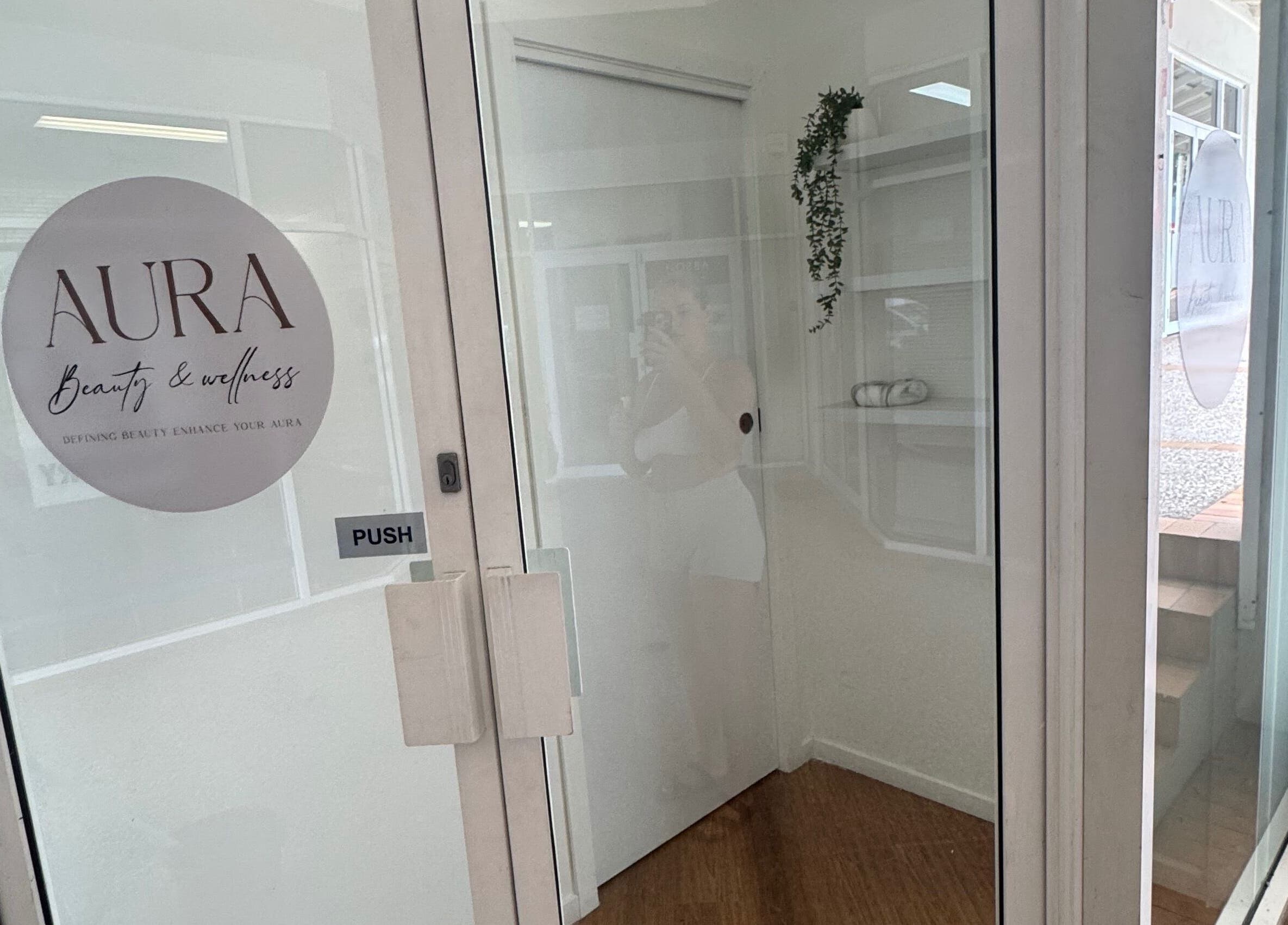 Entrance to AURA Beauty and Wellness in Nerang, Queensland, AU with glass door and logo.