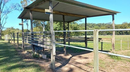 Outdoor rustic pavilion at Elara Lodge, Yandina Creek, Queensland, AU, surrounded by lush greenery.