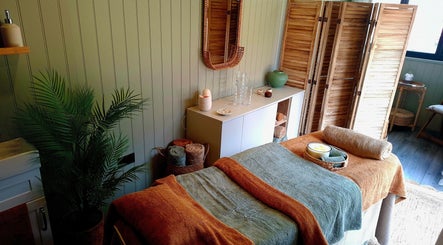 Relaxing treatment room at The Holistic Healing Hut, Gweek, England, GB with cozy bed and calming decor.