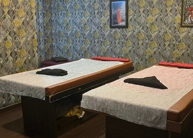 Elegant massage room at The SOFITEL wellness, Manikonda, Hyderabad, Telangana, IN with plush beds and decor.