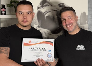 Team member at Moj Frizer in Нови Сад, Војводина, RS holding certification with a colleague, celebrating excellence.