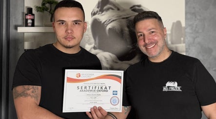 Team member at Moj Frizer in Нови Сад, Војводина, RS holding certification with a colleague, celebrating excellence.