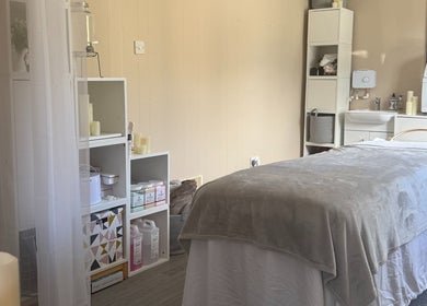 Relaxing treatment room at Made Beauty, Nazeing, England, GB with cozy massage bed and soft lighting.
