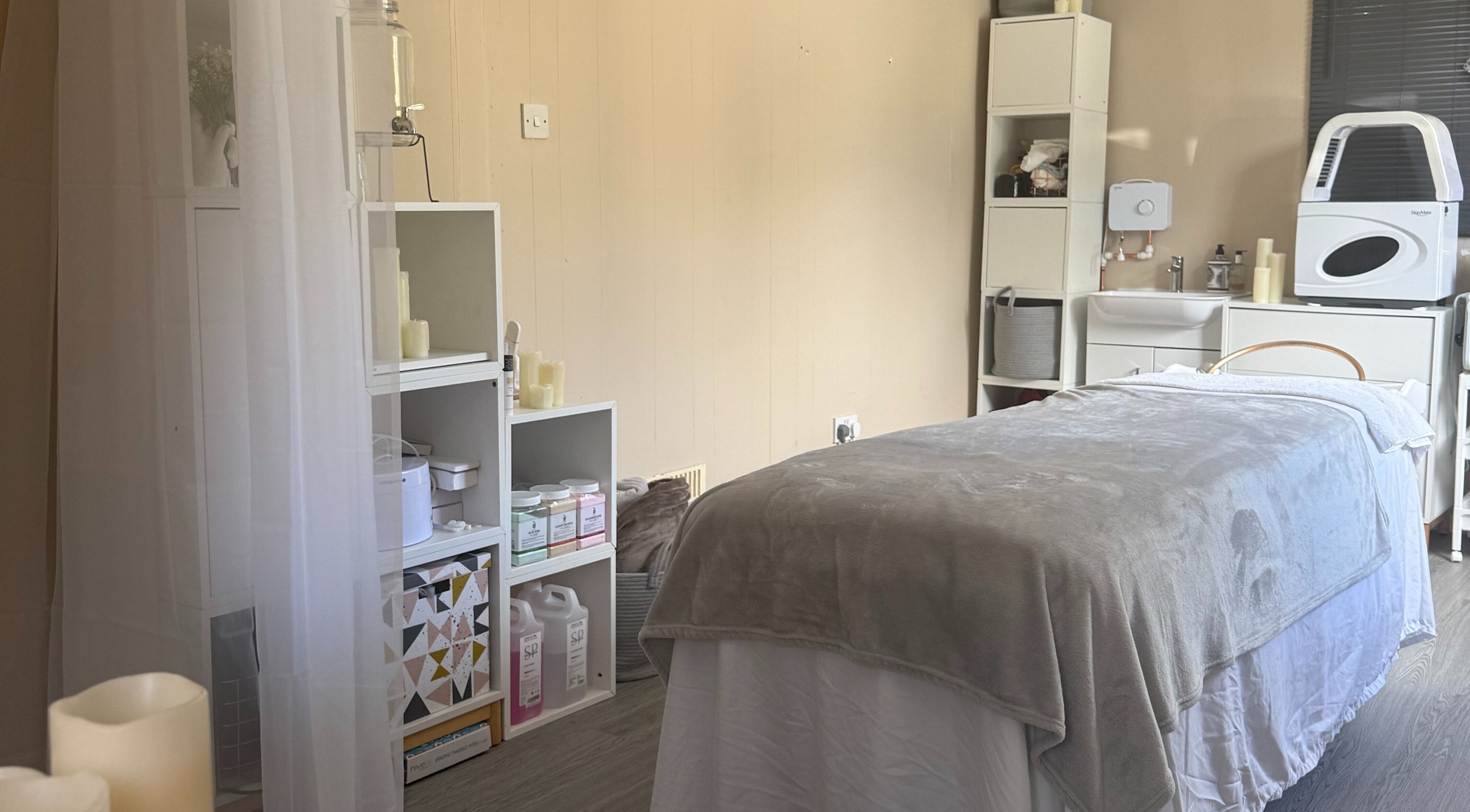 Relaxing treatment room at Made Beauty, Nazeing, England, GB with cozy massage bed and soft lighting.