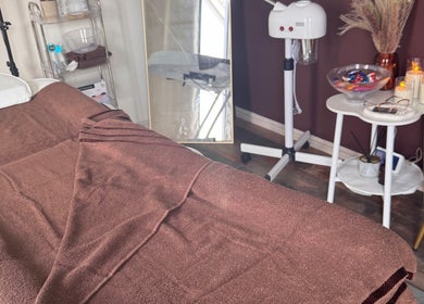 Cozy massage bed at No.6 Beauty Lounge in Winterbourne, England creates a relaxing spa atmosphere.