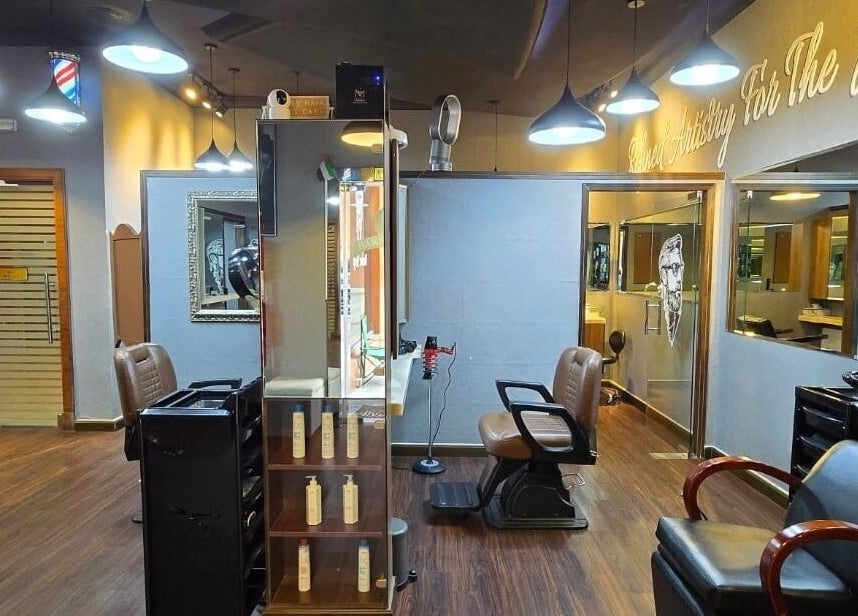 Sophisticated interior of Figaro Gentleman L.L.C, Abu Dhabi, featuring modern barber chairs and stylish decor.