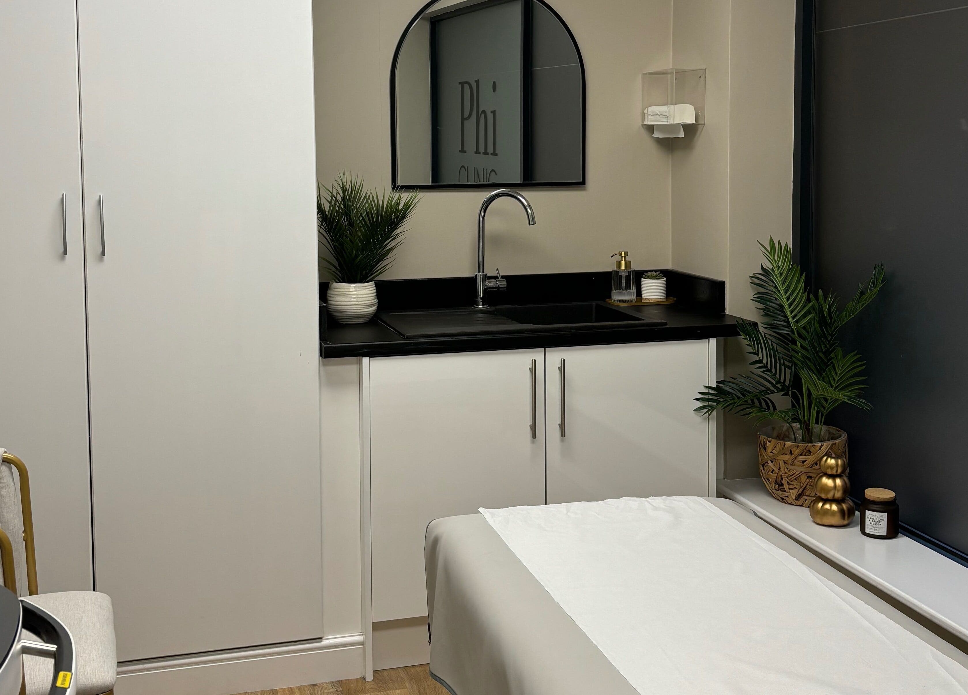 Modern treatment room at Phi Clinic IOM, Douglas, Isle of Man, GB with sleek cabinetry and tranquil decor.