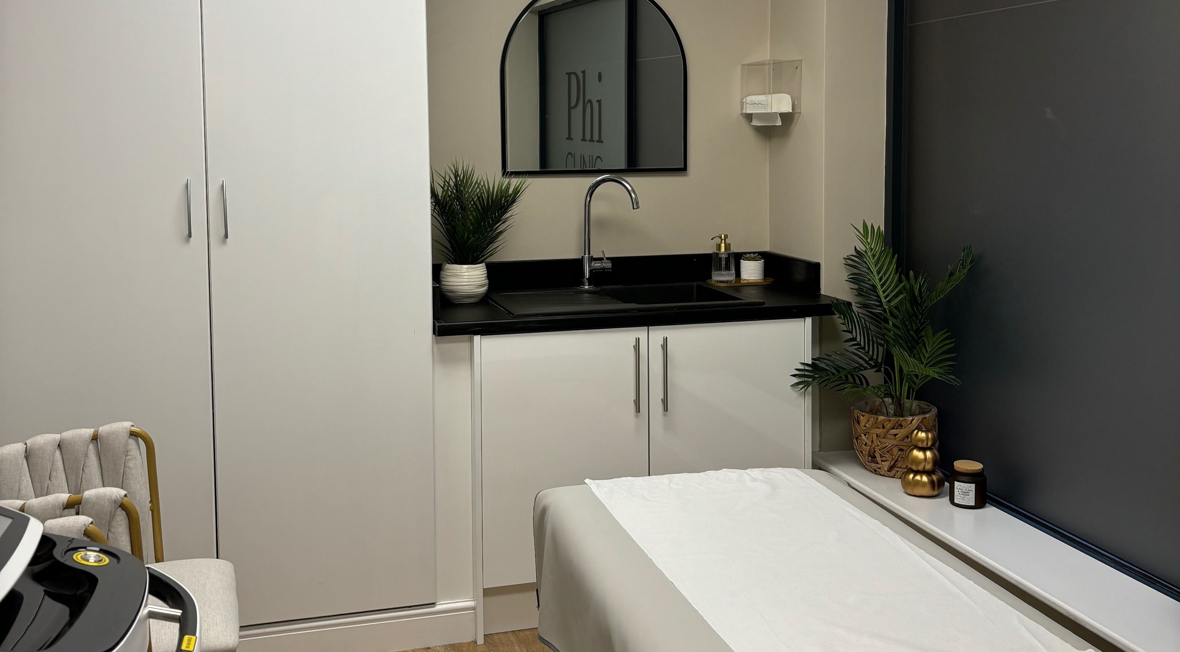 Modern treatment room at Phi Clinic IOM, Douglas, Isle of Man, GB with sleek cabinetry and tranquil decor.