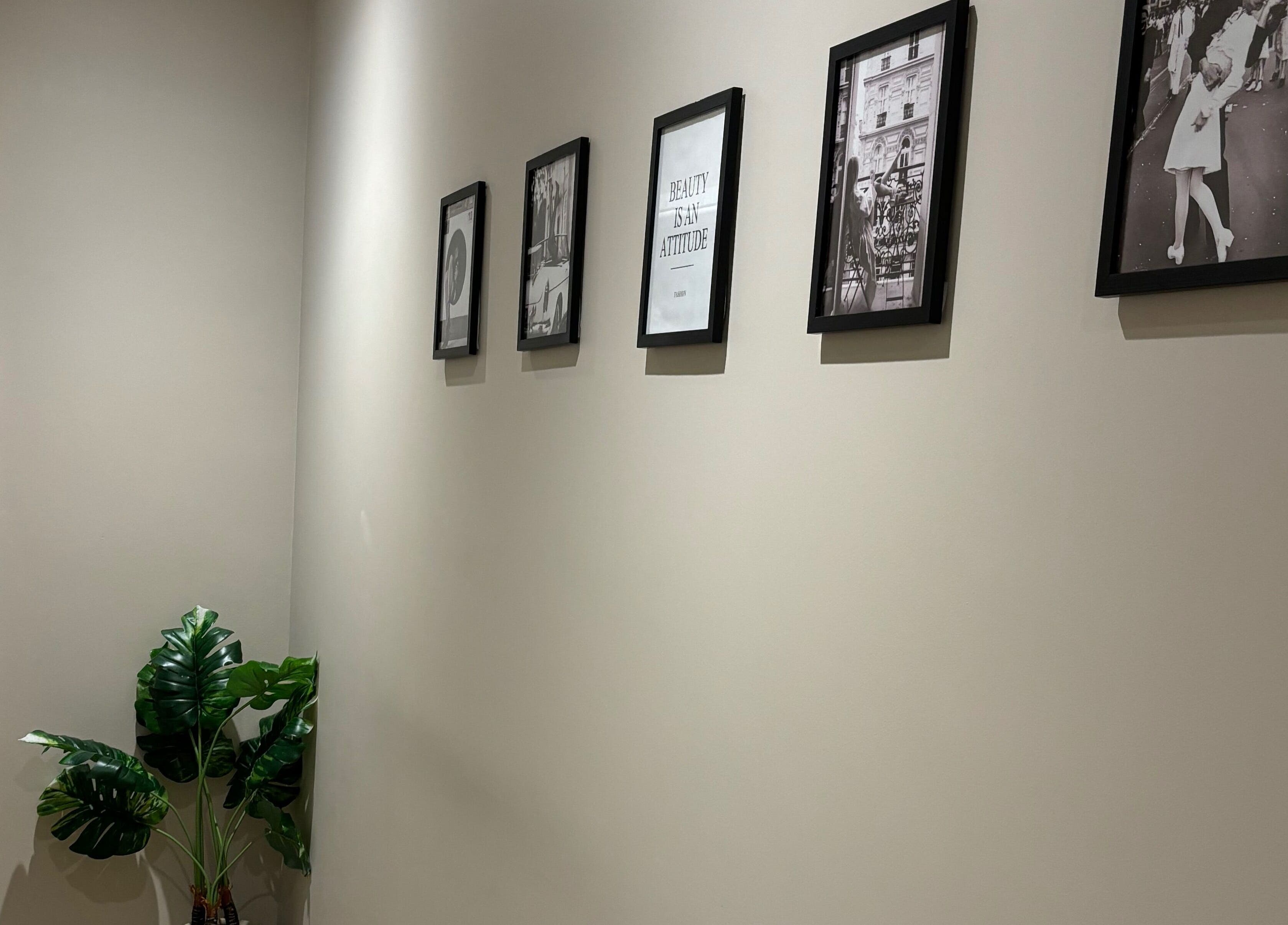 Elegant hallway at Phi Clinic IOM, Douglas, Isle of Man with framed art and plant decor.