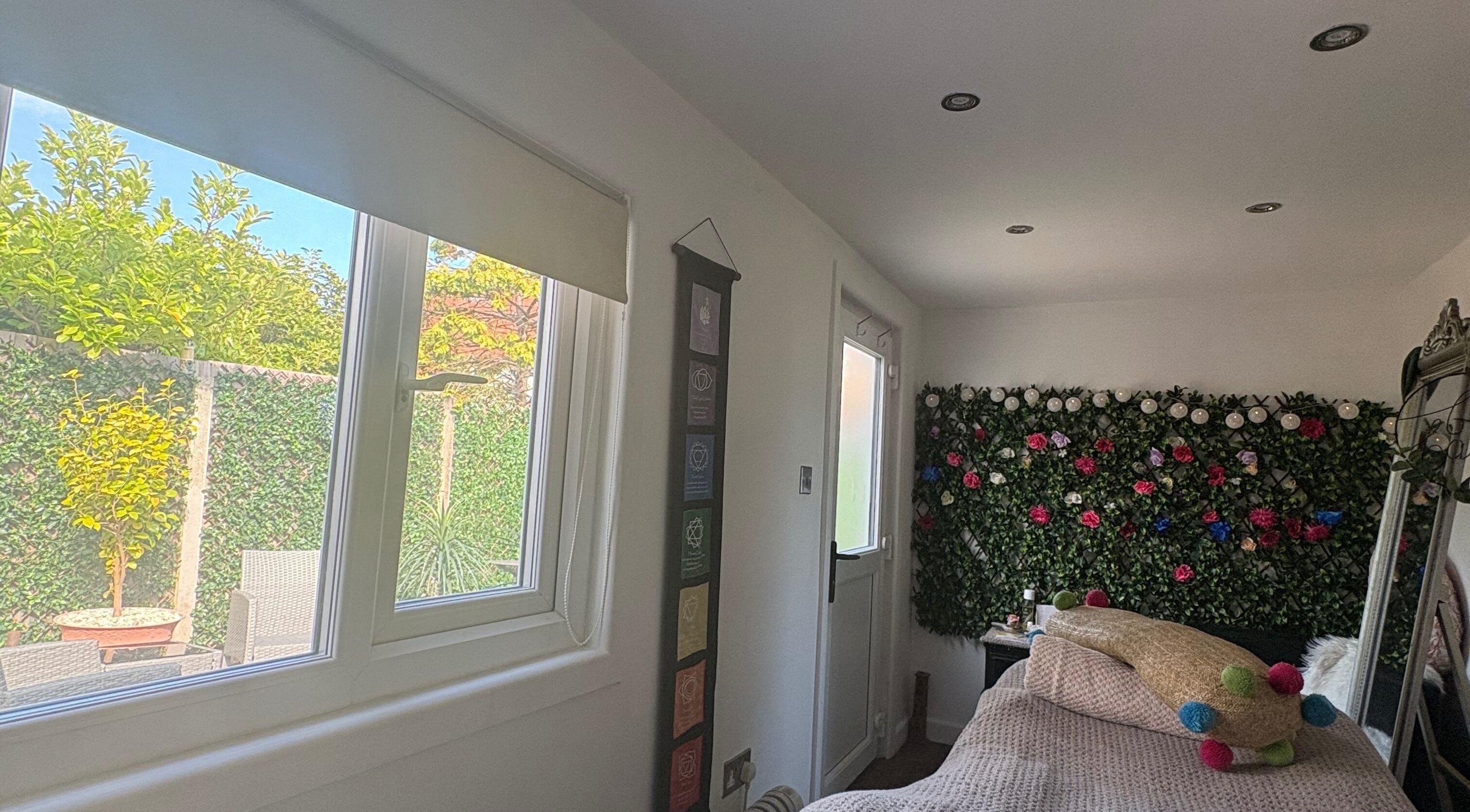 Peaceful room at Pampered@62 in Blackpool, England featuring a floral wall and garden view.