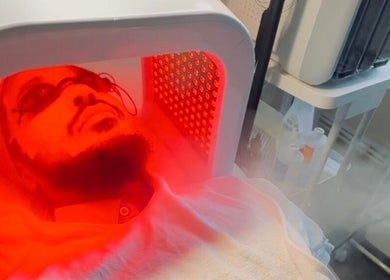 Red light facial treatment at Esthora Aesthetics, London, England, GB, enhancing skin health and relaxation.