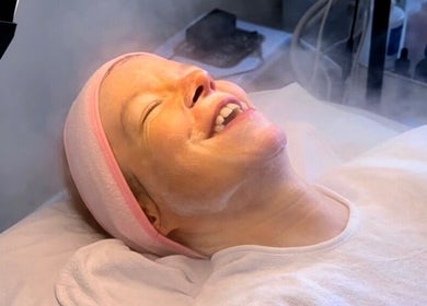 A client enjoying a facial steam treatment at Esthora Aesthetics, London, England, GB.
