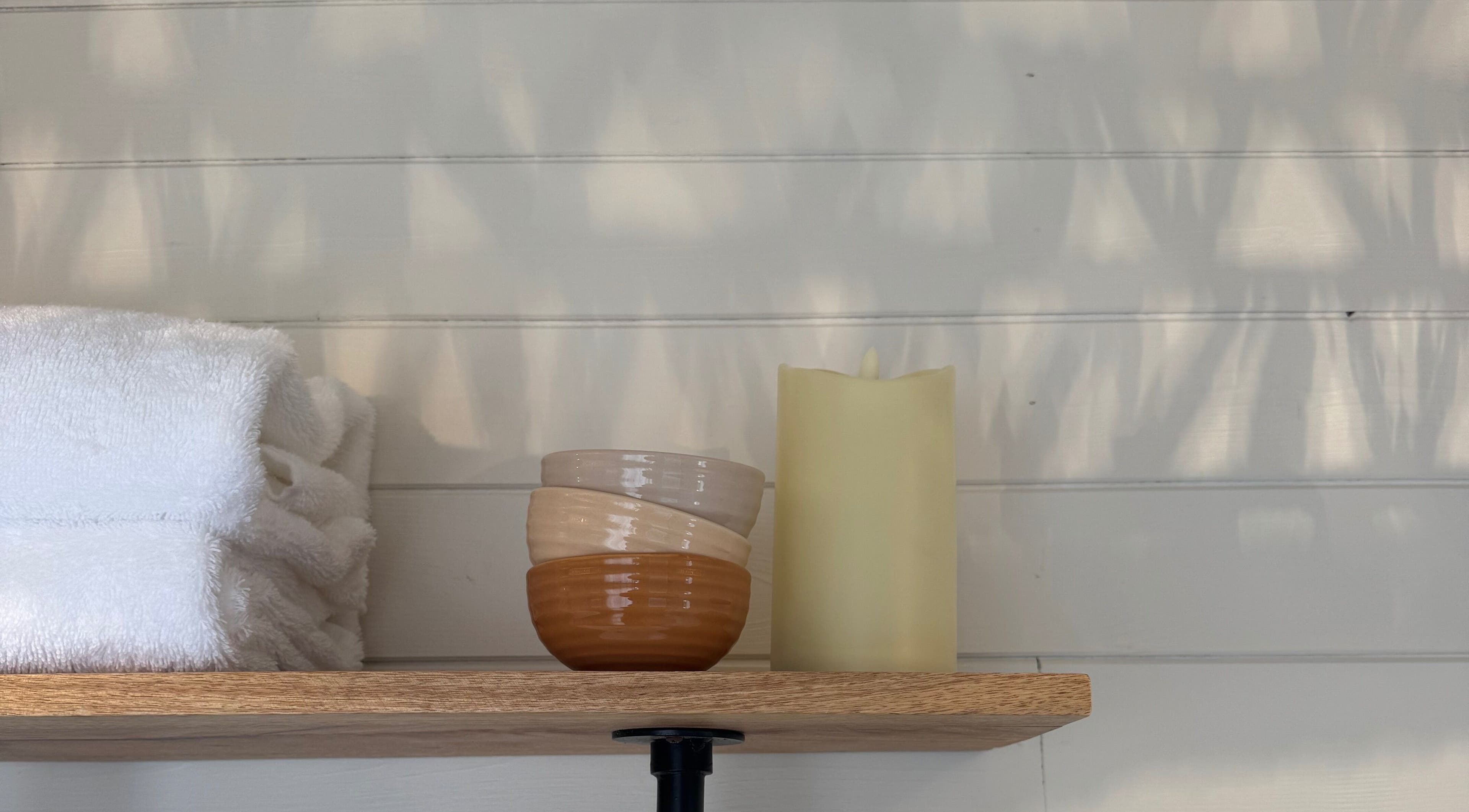 Tranquil shelf with towels, bowls, and candle at Wellness Studio, Bristol, England, GB.