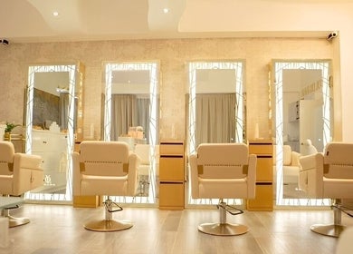 Interior moderno del Yolo Salon en San Pedro Garza García, Nuevo León, MX, con espejos iluminados y sillas de salón.