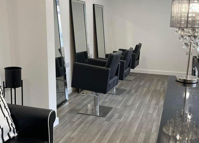 Sleek interior of Glammedbyamelia salon in Plymouth, England, GB, showcasing modern styling chairs and mirrors.