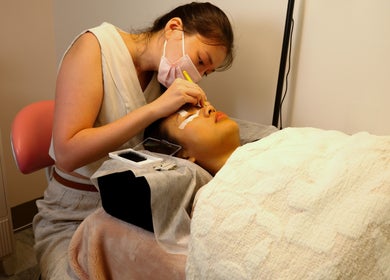 Lash treatment at PRECISION LASH & BROW in Bethesda, Maryland, US. A specialist carefully applies lash extensions.